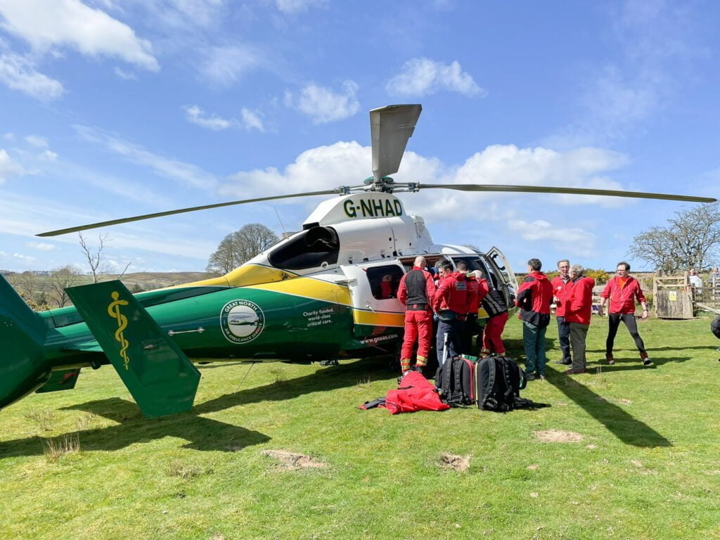 Cleveland Mountain rescue lifting an injured man into the Yorkshire Air Ambulance
